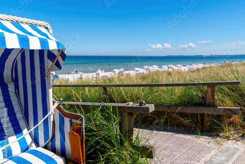 Fototapeta Naklejka Na Ścianę i Meble -  Blue white beach chair with the Beach Idyl of Scharbeutz in background, Baltic sea, Germany
