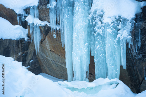 Huge blue-colored icicles on a rock wall © Menyhert