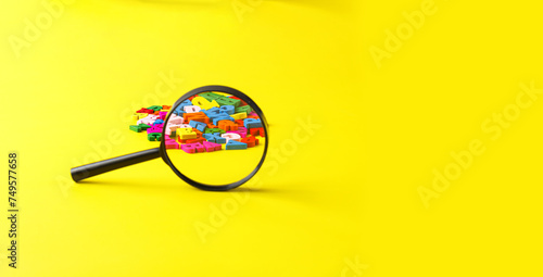 colored letters of the alphabet with a magnifying glass on a yellow background