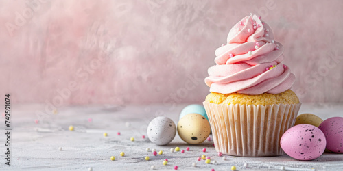 Easter cupcake with pink whipped cream and Easter eggs on pink gray background. Close up. Banner for Easter celebrations.