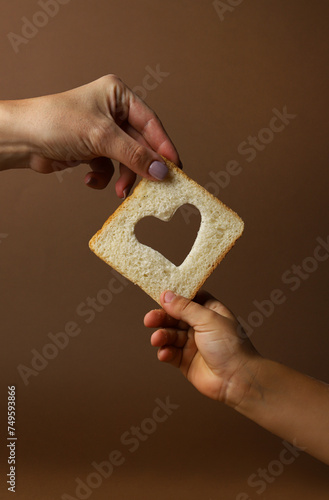 Bread in hands. Mother and child. Hands of mother and child. Heart in hands. Love.