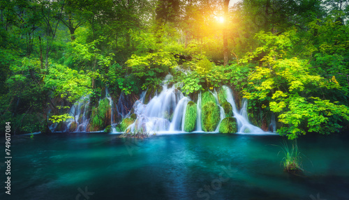 Waterfall in green forest in Plitvice Lakes, Croatia at sunset