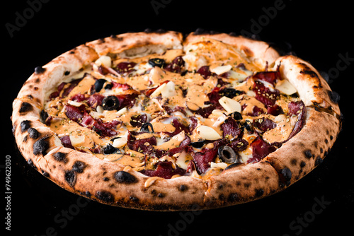 Italian dinner pizza with beef, olives, garlic, cheese, sauce and spices isolated on black.
