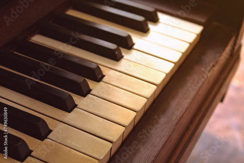 Close-up of the keys of an old piano, in a vintage style with yellowed keys. Image of a musical piano from the last century.