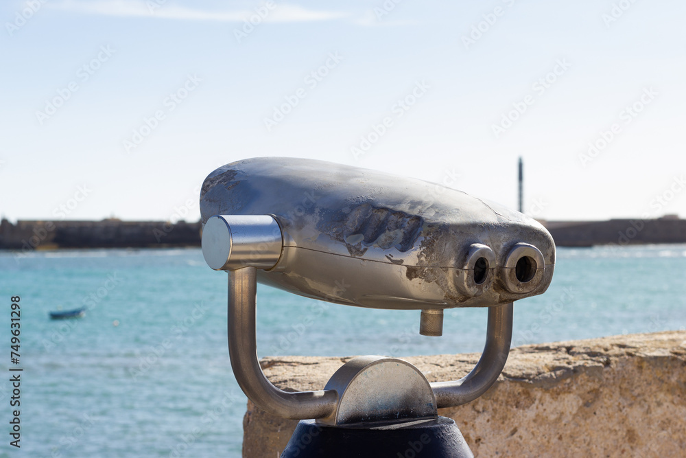 Fototapeta premium Tourist binoculars at the viewpoint of Santa Catalina Castle in Cadiz, overlooking the sea.
