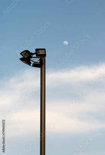 View of a street lamp and the white moon in the sky photo