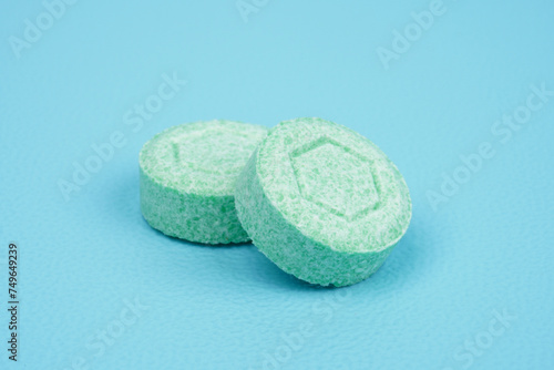 One green colored tablet against blue background