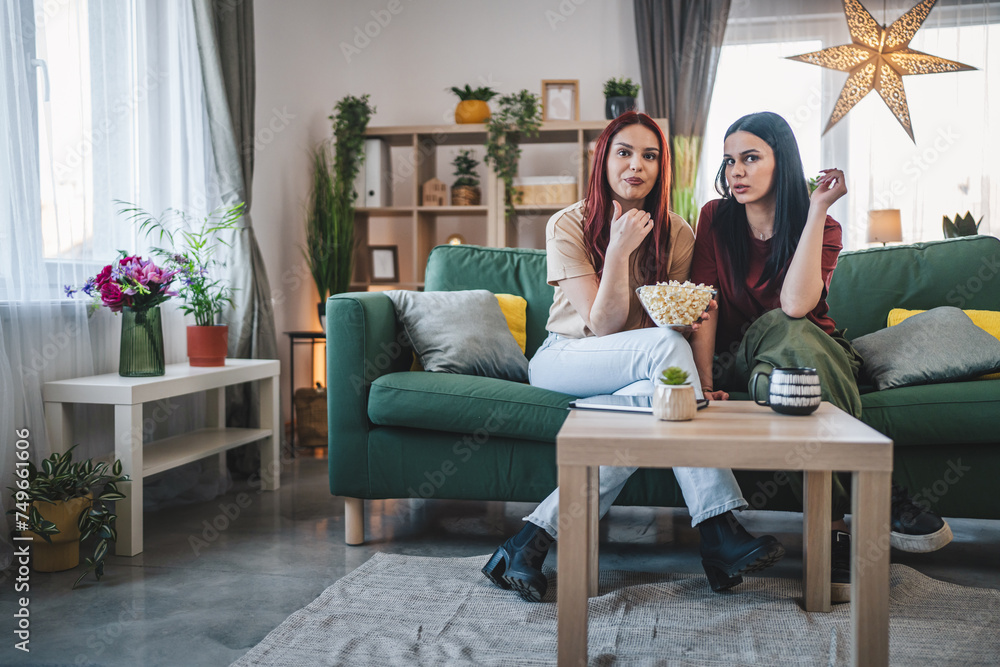 two women caucasian teenage friends or sisters watch movie tv at home two women caucasian teenage friends or sisters watch movie tv at home