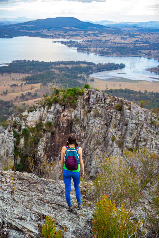 Naklejka premium hiker girl admires the panorama of moogerah national park from the top of mount greville, hiking in south east queensland near brisbane and gold coast