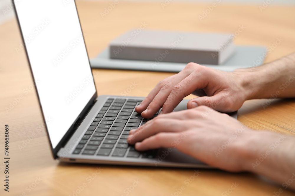 E-learning. Man using laptop during online lesson at table indoors, closeup