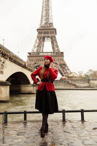 sexy girl posing in front of the elf tower. A model in a red beret and jacket walks through Paris. city ​​of lovers. visit to paris