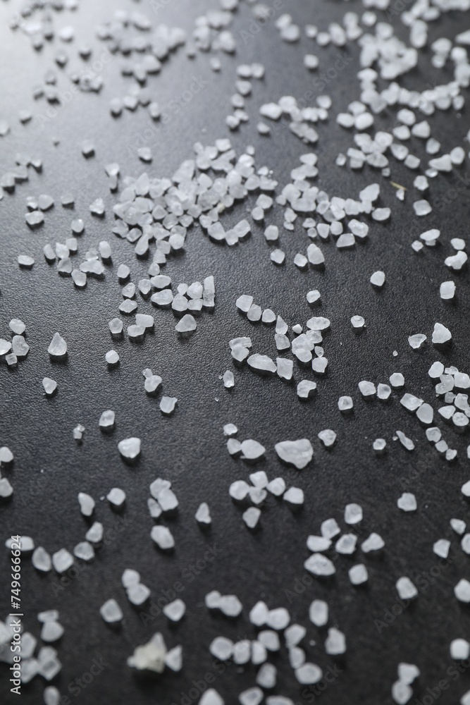 Fototapeta premium Scattered white natural salt on black table