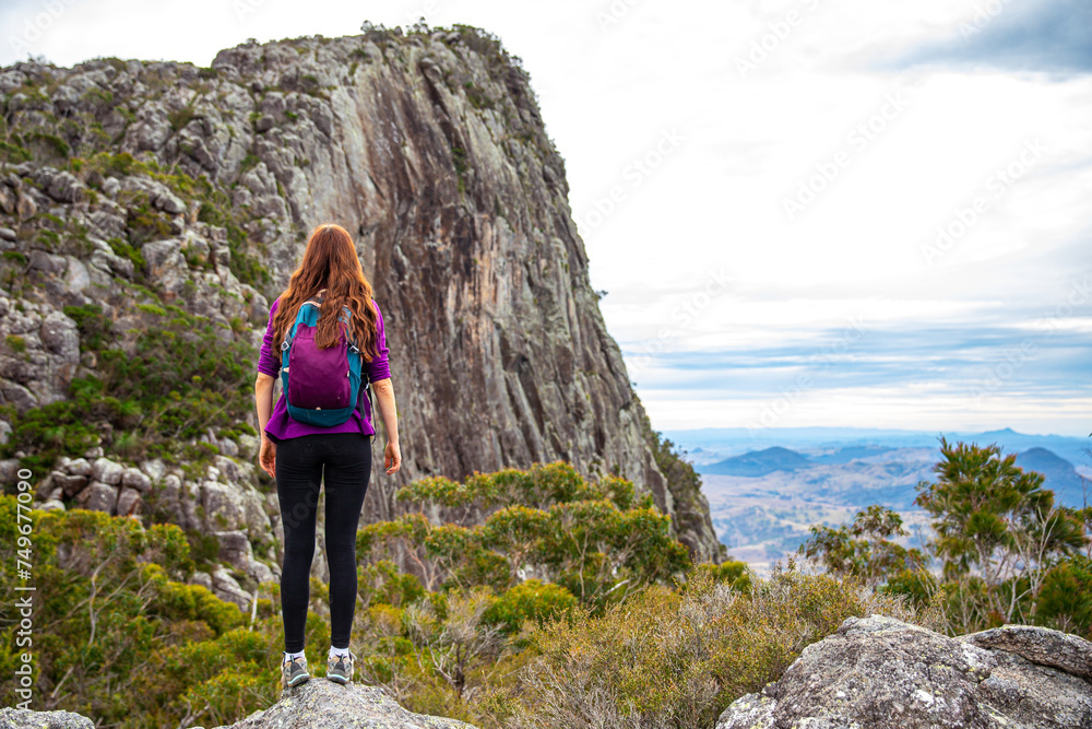 Naklejka premium hiker girl admiring the panorama of mountains on the way to the top of mount maroon, mount barney national park, queensland, australia