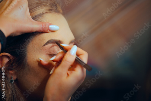 Woman Having Her Eyebrows Done with a Gel Pencil. Client having her brows redefined by a professional makeup artist 
 photo