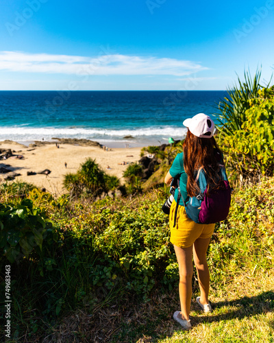 girl looking for whales from the cliffs of point danger above duranbah beach in coolangatta near gold coast, queensland, australia; relaxing coastal walk in a scenic area photo