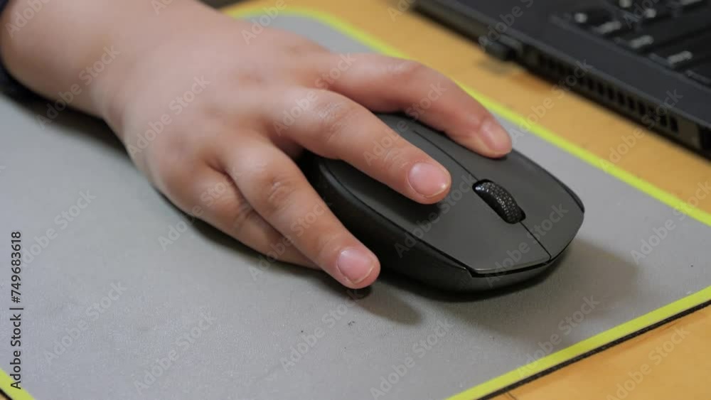 Child holds the computer mouse,child learns and plays on the computer Child holds the computer mouse,child learns and plays on the computer