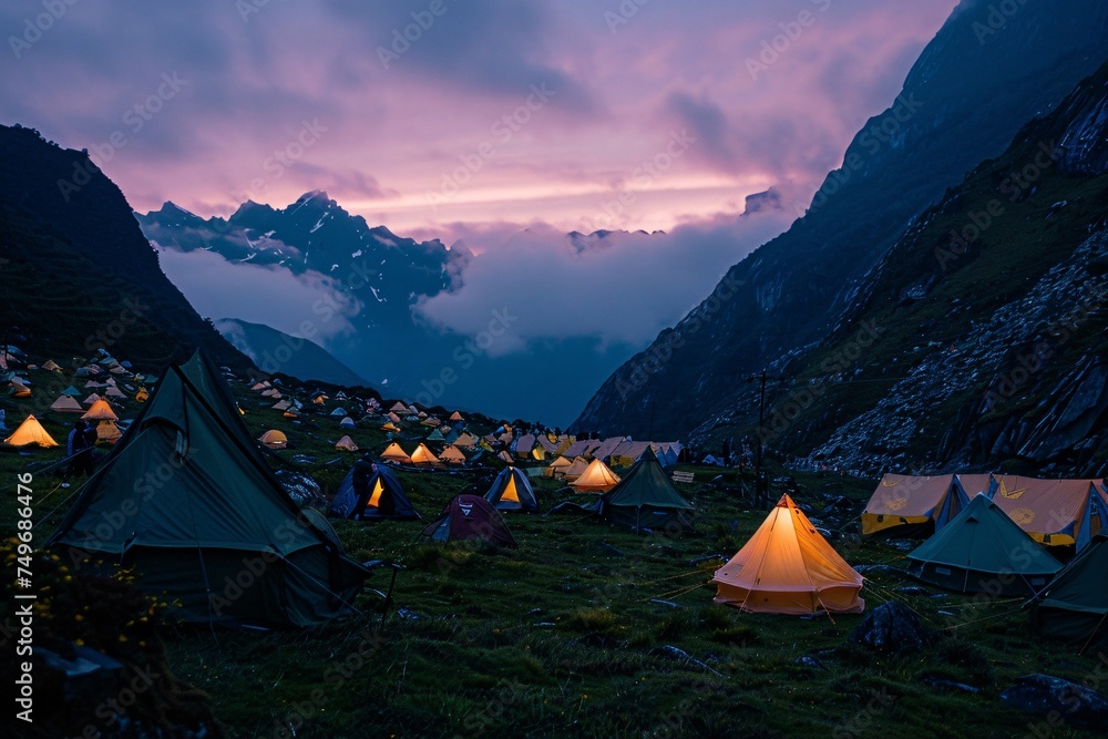 An atmospheric scene of a basecamp at dusk with the setting sun casting long shadows and tents glowing from within