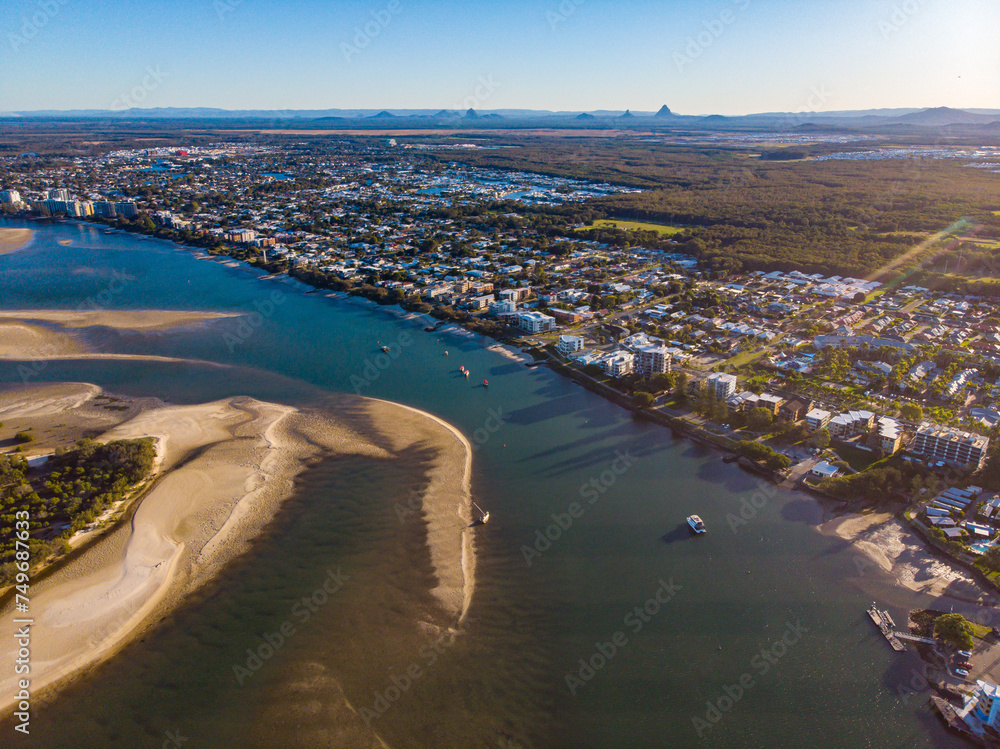 sunset over north bribie island and caloundra in south east queensland, australia; people passing to the island during low tide; Pumicestone Passage	