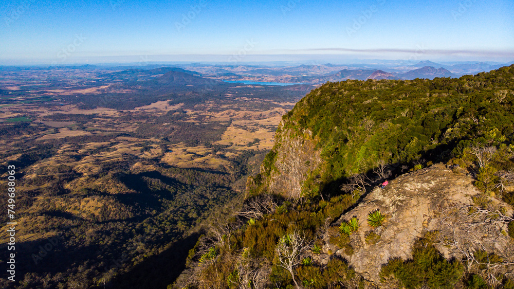 aerial view of hiker enjoying a sunset over mountains in main range national park, queensland, australia - famous bare rock lookout aerial view of hiker enjoying a sunset over mountains in main range national park, queensland, australia - famous bare rock lookout
