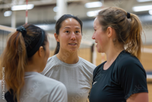 Female volleyball coach talking to student on training