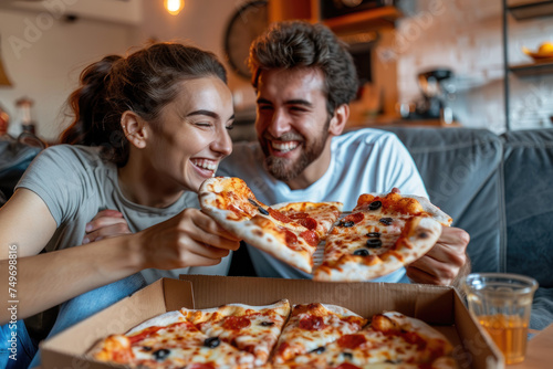 Happy couple eating pizza while watching movie at home