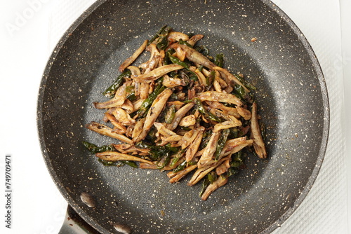 Delicious salted fish stir-fry with green chilies, perfect with warm white rice, each bite a delightful experience.