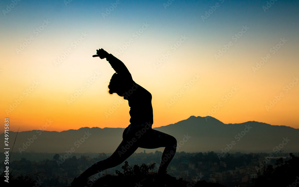 silhouette of a woman doing yoga in sunset