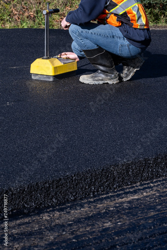 Road construction, technician testing freshly laid asphalt compaction with a nuclear density gauge machine
 photo