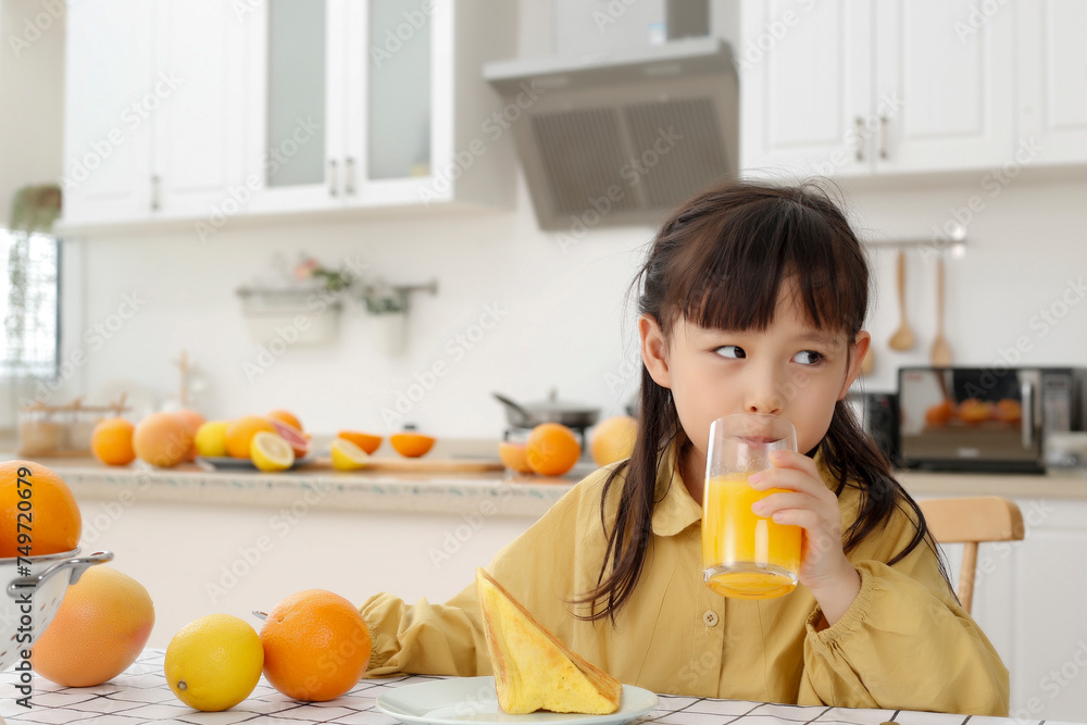 Made in kitchen Asian daughter drinks juice and eats bread