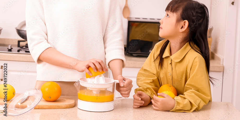 Asian mother making fresh juice with her daughter Asian mother making fresh juice with her daughter