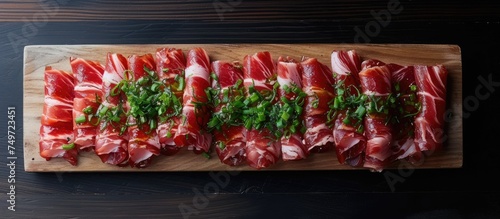 A wooden cutting board is seen with neatly arranged slices of red pork belly meat. The succulent and juicy meat is expertly sliced, ready to be cooked and enjoyed.