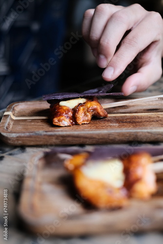 Chicken skewers with sauce on a plate over a light grey slate, stone or concrete background. in Hong Kong fine diningrestaurant	
 photo