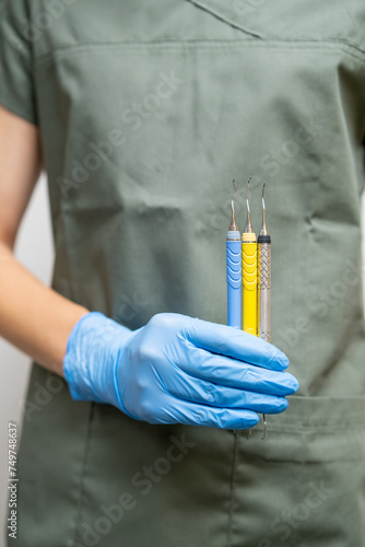 Dental probes in dentists hand in rubber gloves.