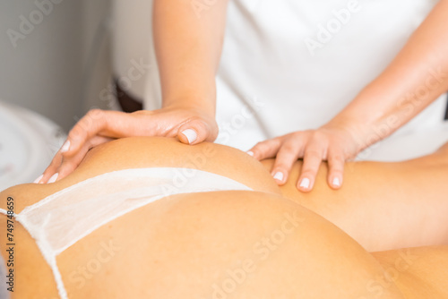 Beautician performs anti-cellulite massage for lady client