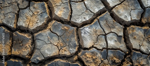 A detailed view of a cracked surface of mud, depicting the effects of dryness, drought, and desertification. The image showcases the need for environmental protection and combating these issues.