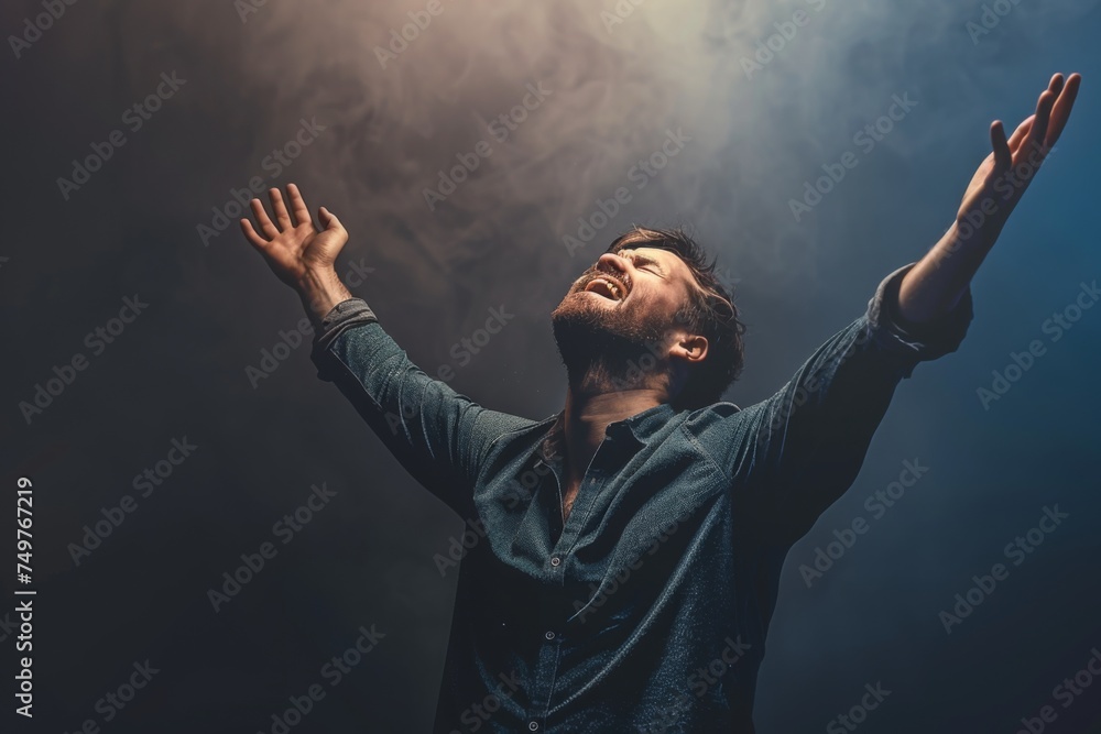 A Christian man praying to God crying and emotional with his arms raised