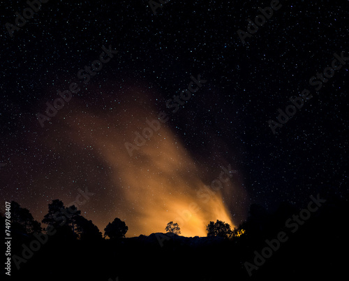 Wildfire in the mountains during starry night 