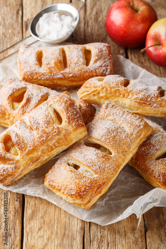 Homemade Puff pastry filled with apples close-up on a wooden table. Vertical