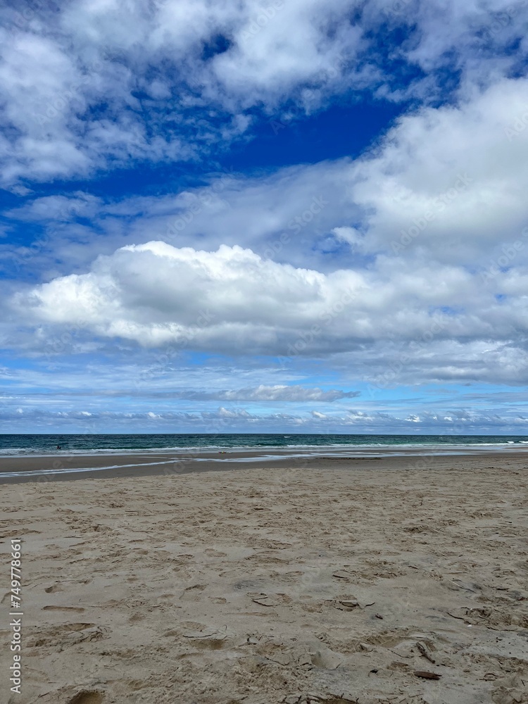 beach with sand and clouds with blue sky