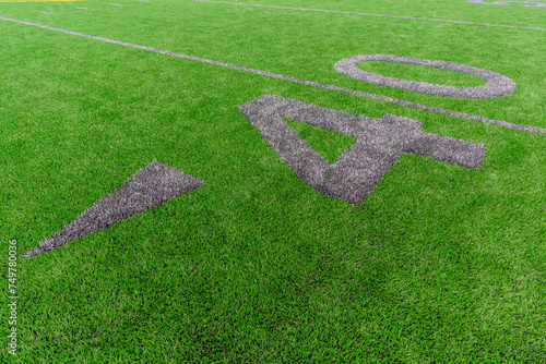 Synthetic turf football 40 yard line and block style numbers in gray.  Practice football turf markings are less obvious and installed in the outfield of a baseball field. 	 photo