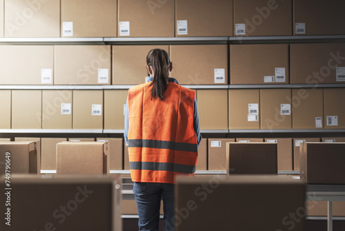 Warehouse worker checking boxes on the conveyor belt