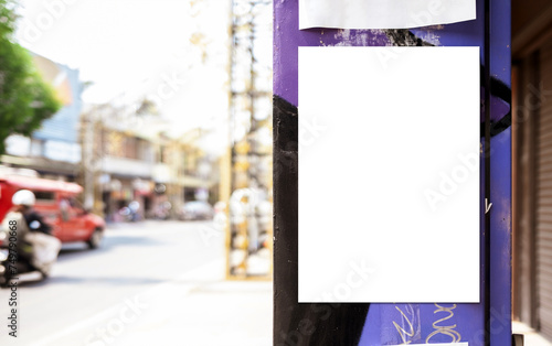 Mockup white paper or white sticker poster displayed on a sidewalk wall. Promotion information for marketing announcements and details with clipping path. photo