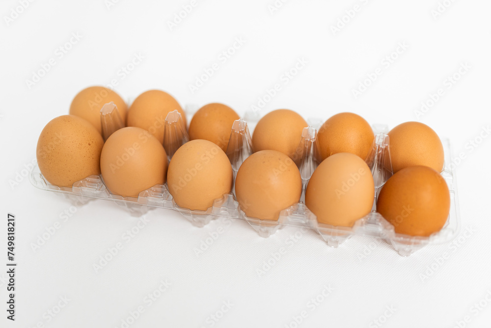 Large brown organic eggs with pink flowers. Food on a clear white background. Mockups. Layout. Large brown organic eggs with pink flowers. Food on a clear white background. Mockups. Layout.