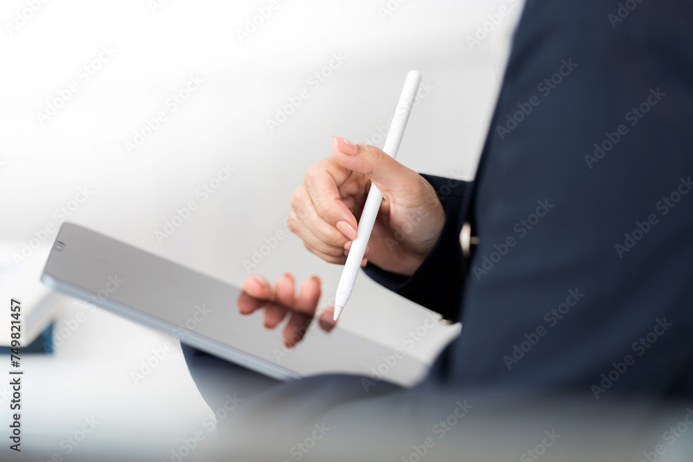 Classic image of a laptop or iPad A pen is used to design or write a business plan and draw ideas from the hands of a female executive in a suit in the office to apply in the present and future. Classic image of a laptop or iPad A pen is used to design or write a business plan and draw ideas from the hands of a female executive in a suit in the office to apply in the present and future.