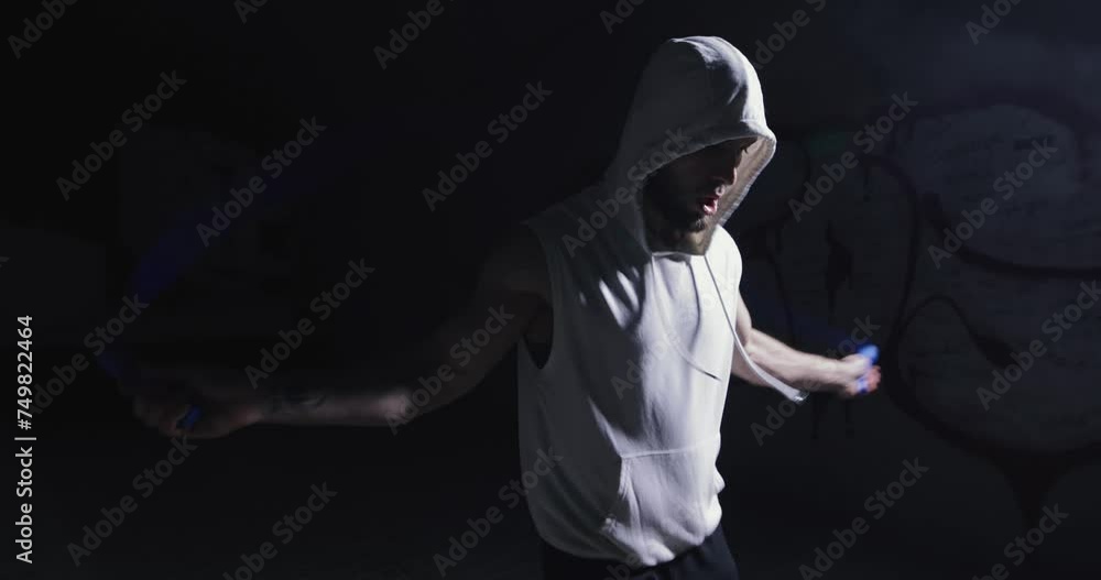 A man jumps rope at dark underground, slow motion A man jumps rope at dark underground, slow motion