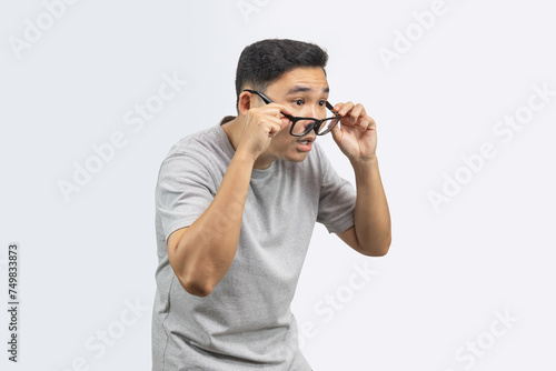 Portrait of man with eyesight problems and  he is adjusting his glasses To look at something