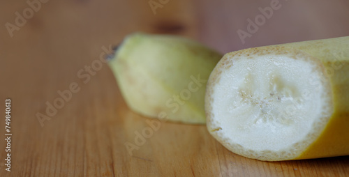 Half-cut banana on a wooden background, close-up, macro photo