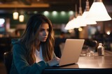 Young tired focused stressed teenager Caucasian girl female overworked woman college high school student preparing exam studying using laptop pc device notebook late evening indoor restaurant cafe bar