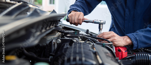 Professional mechanic working on the engine , repairing a car engine automotive workshop with a wrench, car service and maintenance,Repair service. © A Stockphoto