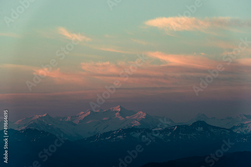 Über dem Großvenediger leuchten orange, gelb und rote Wolken im Sonnenaufgang, Tirol, Österreich photo